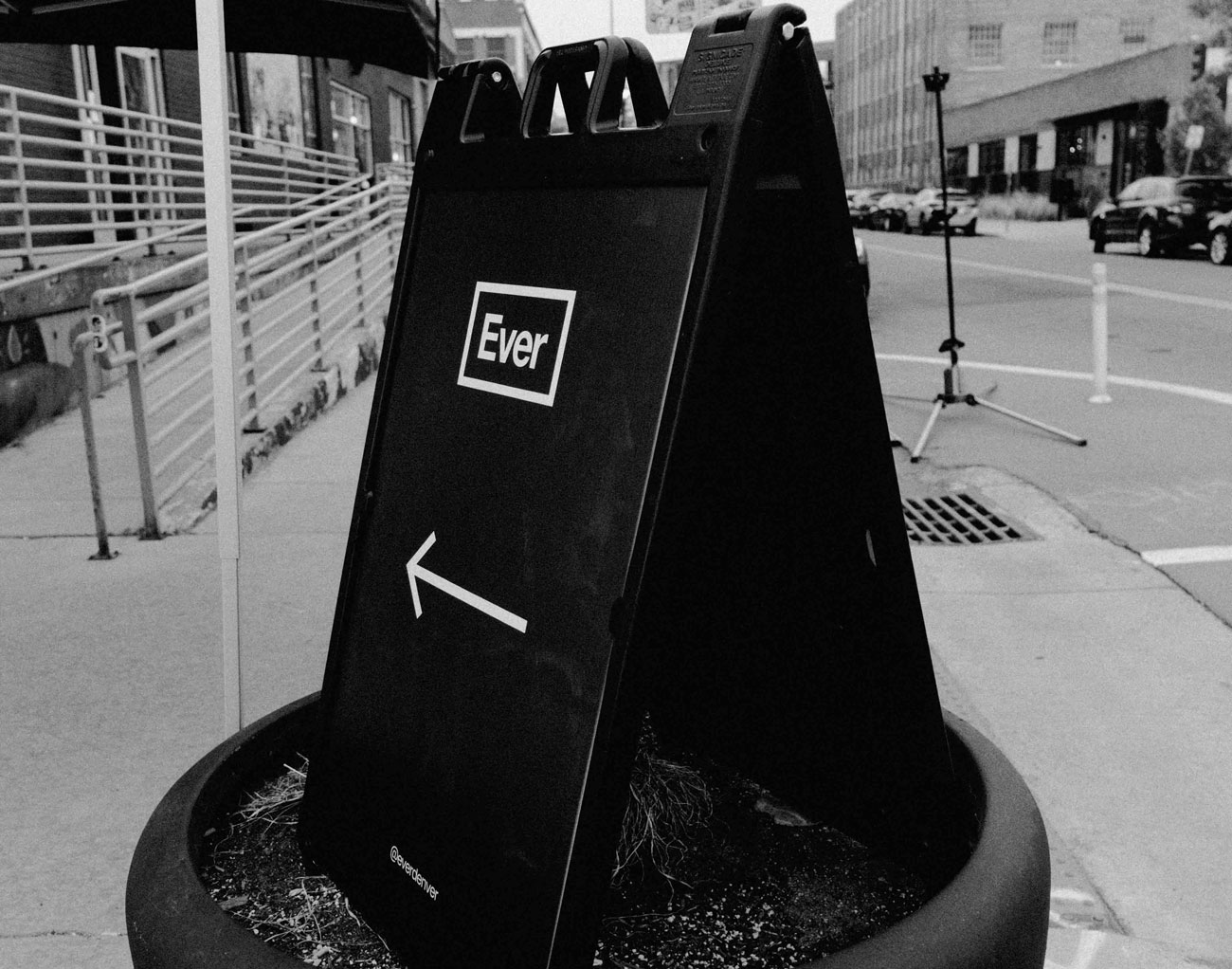 Ever Denver sidewalk sign pointing toward the entrance at 2590 Walnut St